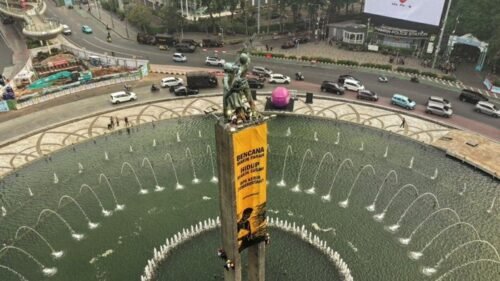 Greenpeace Bentangkan Spanduk di Patung Bundaran HI, Soroti Krisis Iklim